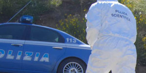 Foto generica di volante del 113 e agente di spalle della polizia scientifica